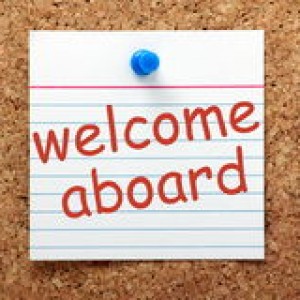 welcome-aboard-phrase-printed-lined-index-card-pinned-to-cork-notice-board-49141680