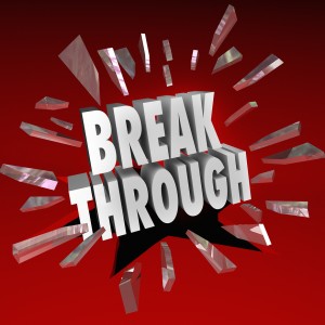 The word Breakthrough breaking through glass to symbolize discovery, invention, creativity, ideas and brainstorming
